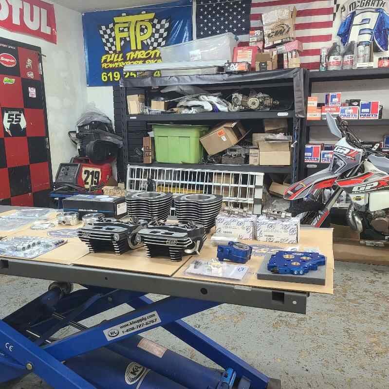 FTP shop interior with engine parts on lift table and dirt bike